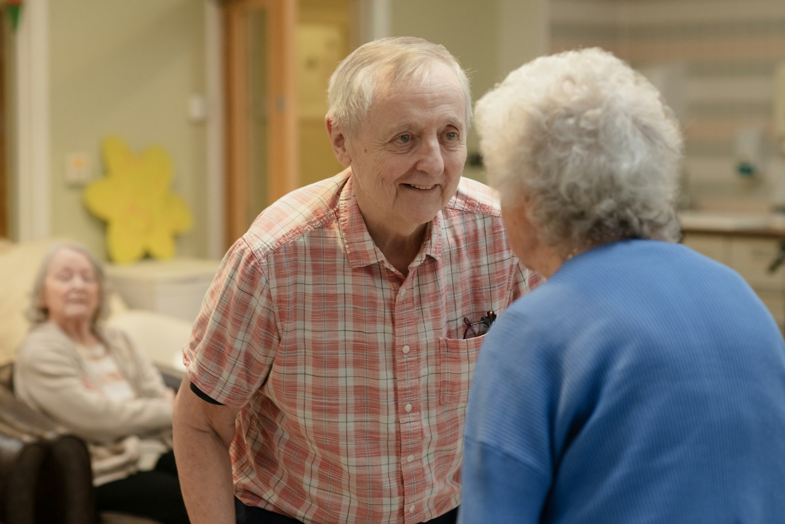 Two adult family home residents enjoying a conversation in a shared living room