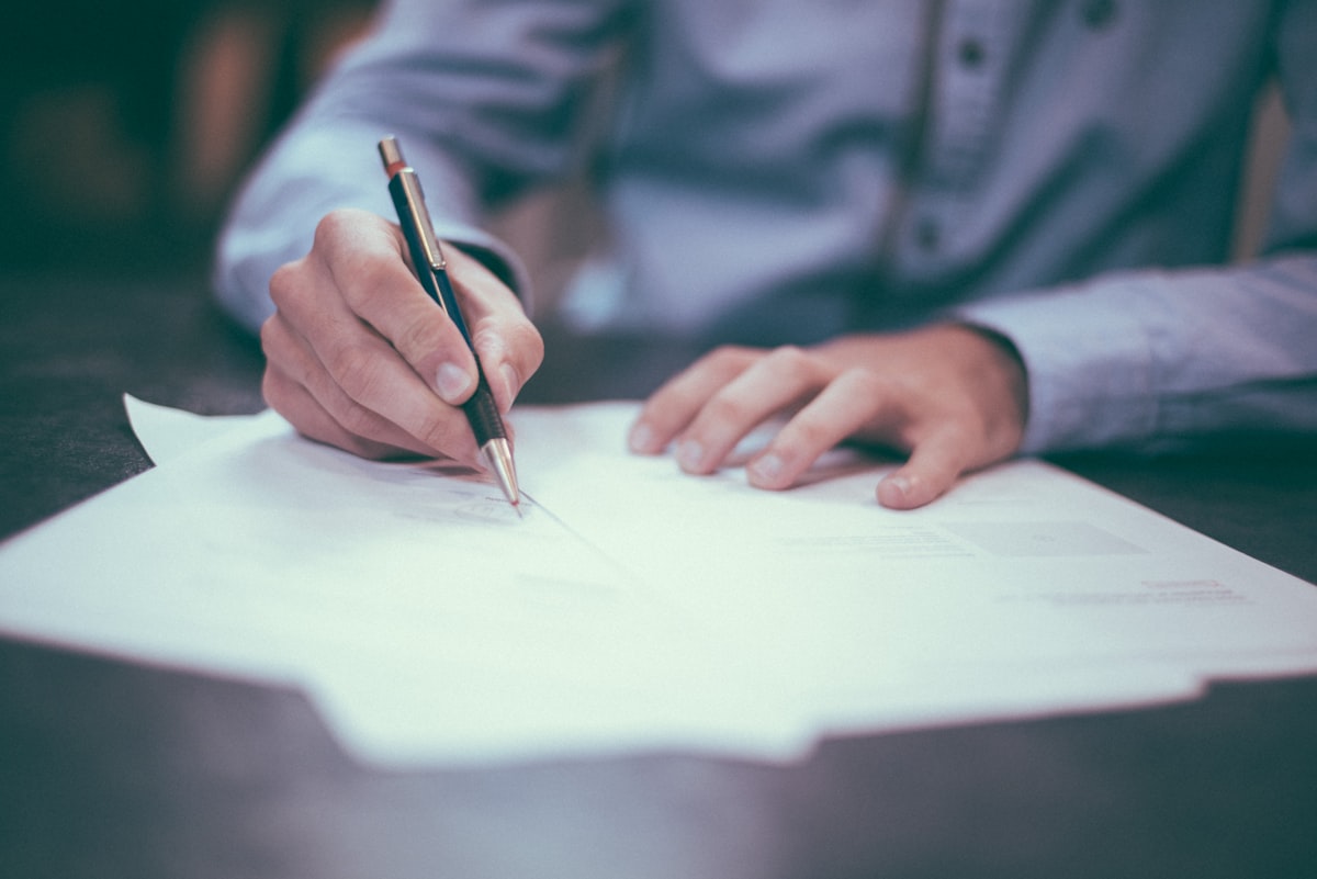 A person reviewing and signing senior care financial paperwork
